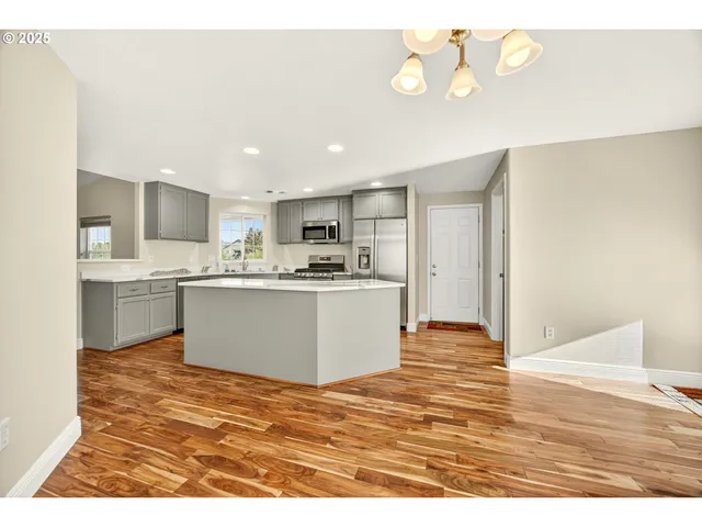 a view of kitchen with kitchen island white cabinets and stainless steel appliances