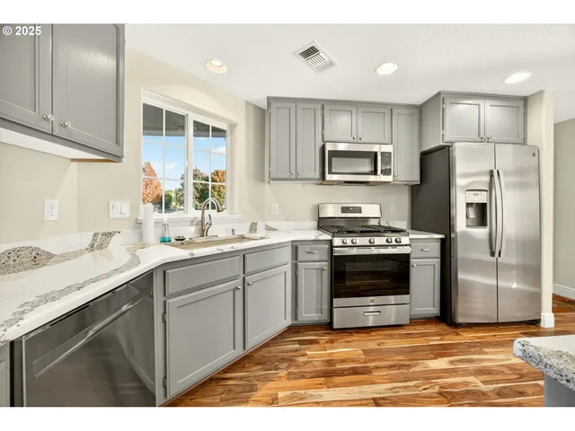 a kitchen with stainless steel appliances a stove sink and refrigerator