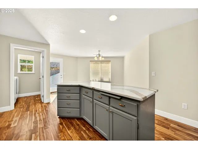 a kitchen with granite countertop a sink and dishwasher with wooden floor