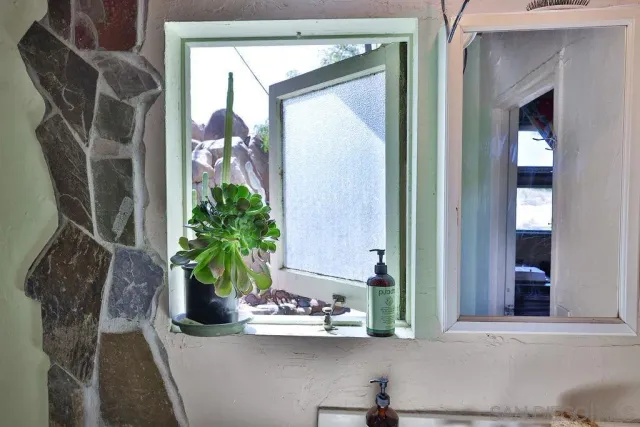 a living room with furniture a lamp wooden floor and a large window