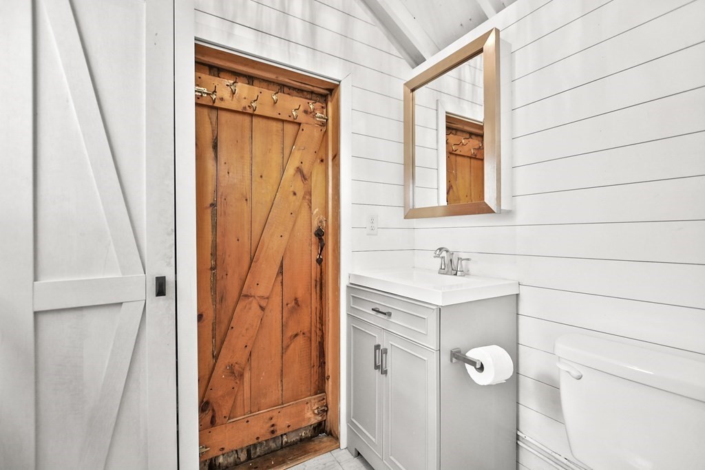 262 Old Wharf Road, Unit 103 Dennis, MA 02639 - Photo 19 of 30 a bathroom with a sink a vanity and a mirror
