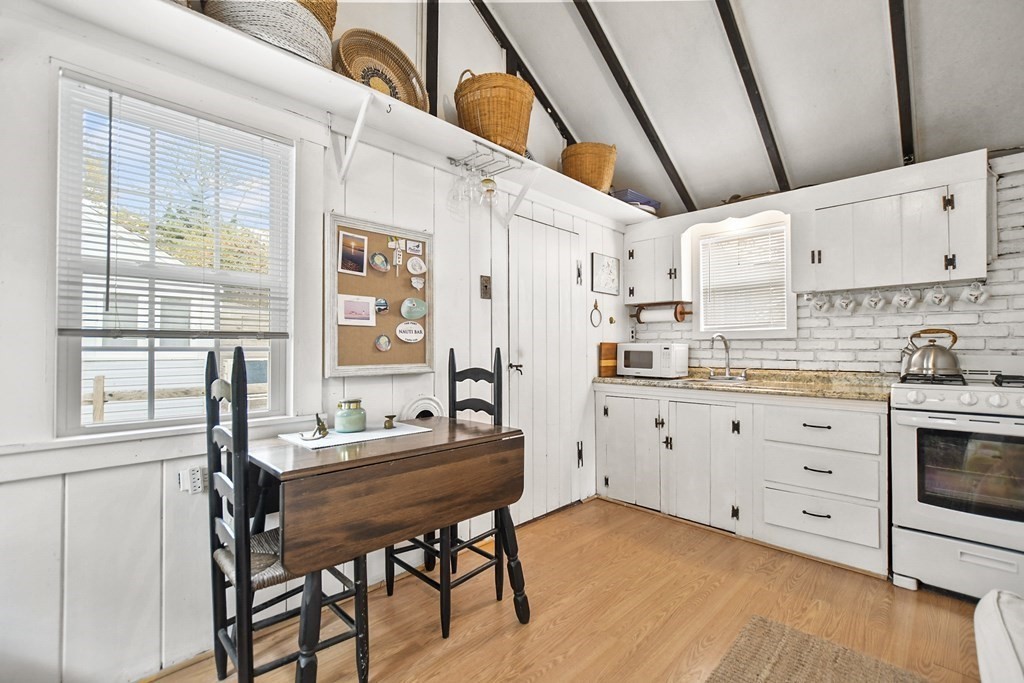 262 Old Wharf Road, Unit 103 Dennis, MA 02639 - Photo 10 of 30 a kitchen with cabinets appliances and a table