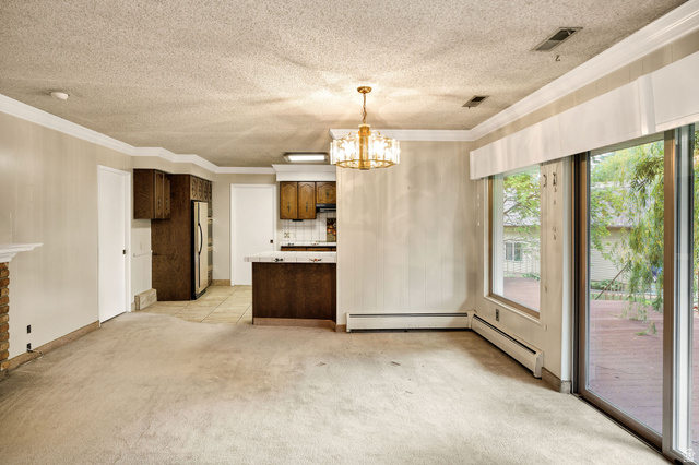 1365 Sumac Drive Logan, UT 84321 - Photo 17 of 66 Spacious living area featuring a stone-clad fireplace and sliding glass doors opening to an outdoor deck