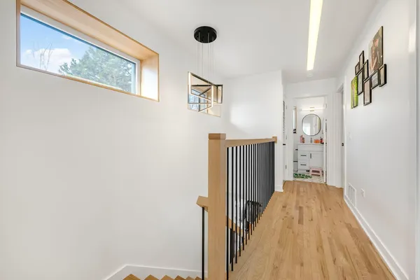 a view of a hallway with wooden floor and staircase