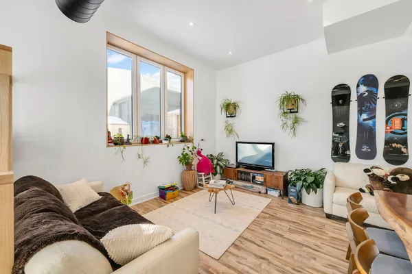 a living room with furniture flat screen tv and a large window