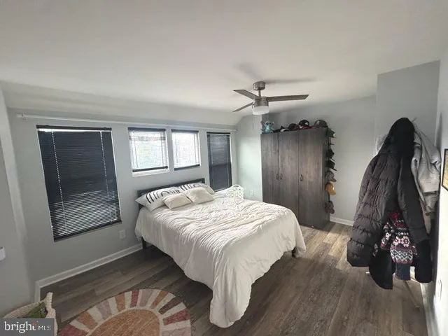 a bed sitting in a bedroom next to a window and a chandelier