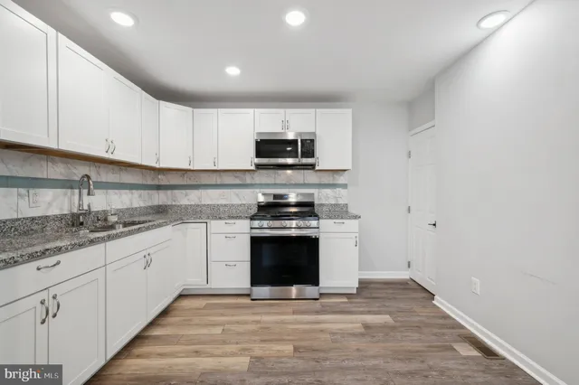 a kitchen with stainless steel appliances granite countertop a stove top oven a sink and dishwasher