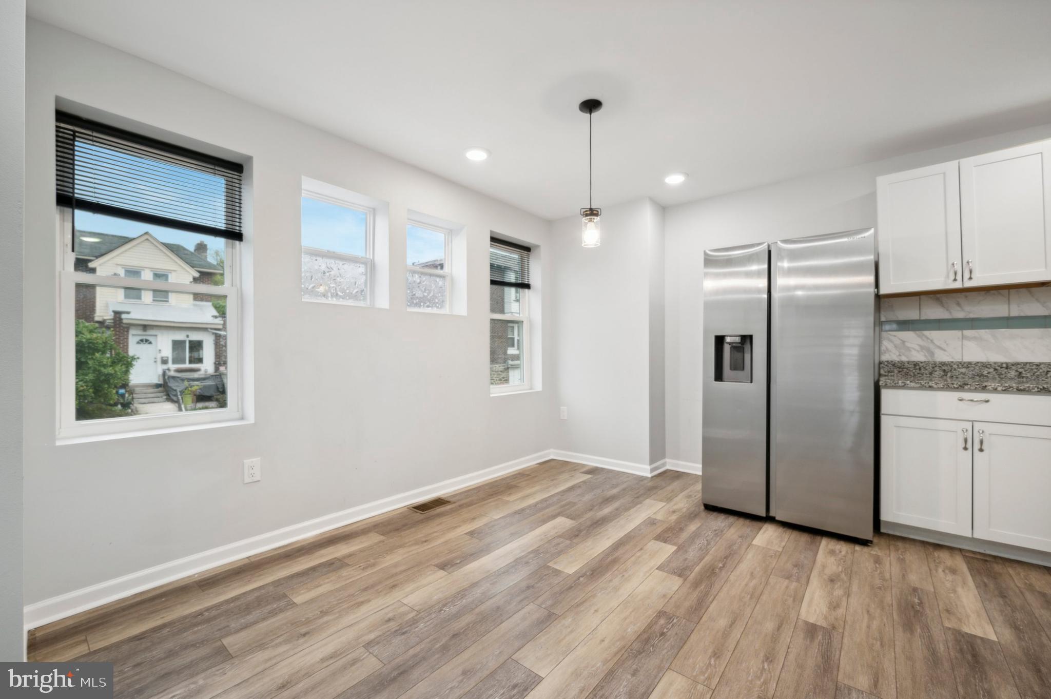 4520 Fernhill Road Philadelphia, PA 19144 - Photo 6 of 30 a kitchen with stainless steel appliances granite countertop a refrigerator a sink and white cabinets with wooden floor