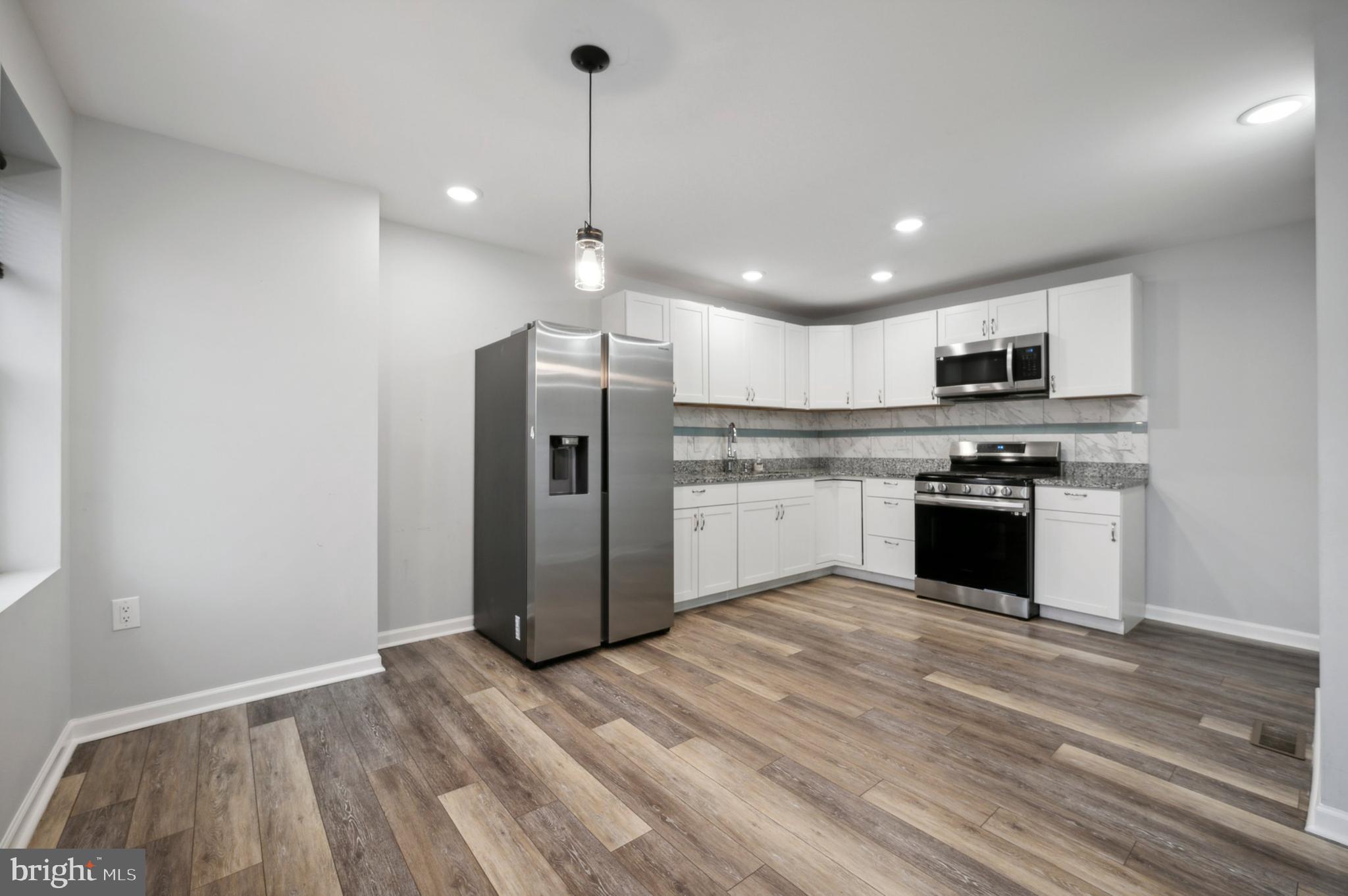 4520 Fernhill Road Philadelphia, PA 19144 - Photo 7 of 30 a kitchen with stainless steel appliances granite countertop a refrigerator a stove a sink and a microwave
