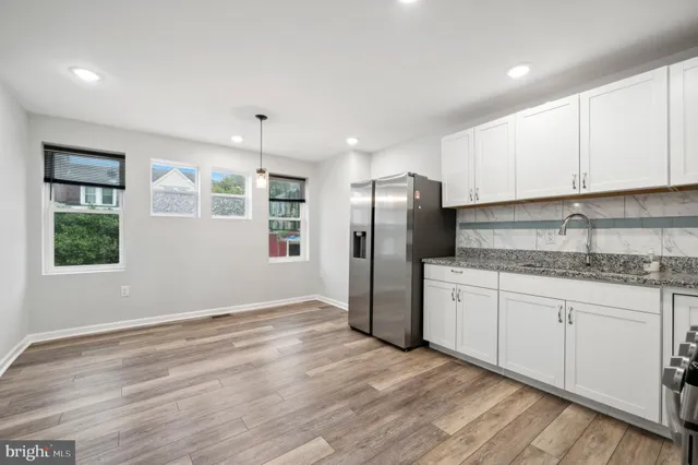 a kitchen with stainless steel appliances granite countertop a refrigerator and a stove top oven