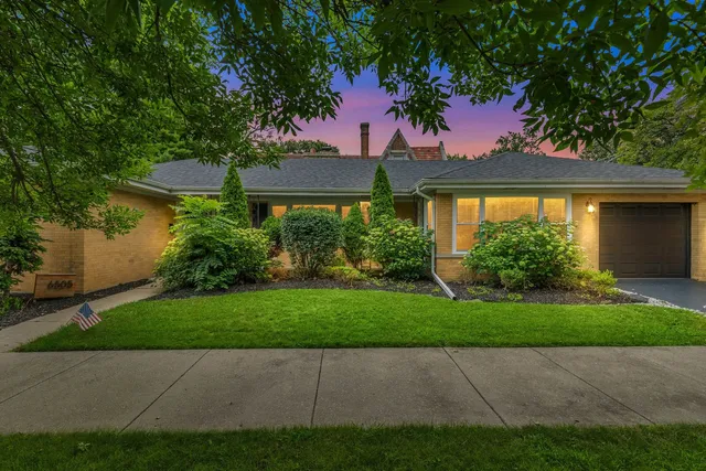 a front view of a house with a yard and potted plants