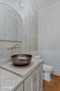 a bathroom with a granite countertop toilet and a sink