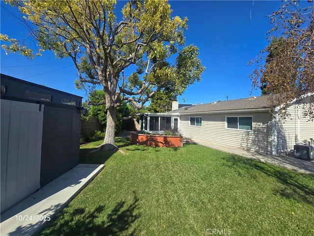 a front view of a house with a garden and trees
