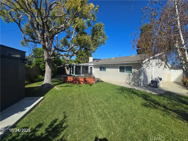 a view of a house with backyard and sitting area