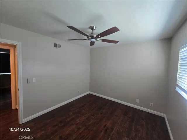an empty room with a window and a fan