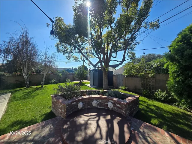 a view of a backyard with table and chairs plants and trees