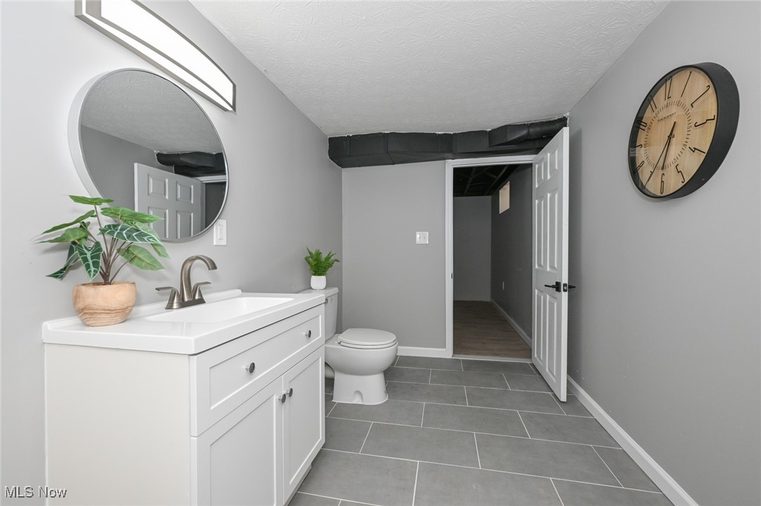 263 Forbes Road Bedford, OH 44146 - Photo 20 of 20 Bathroom featuring tile patterned floors, vanity, toilet, and a textured ceiling