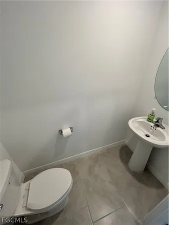 a bathroom with a sink toilet and a mirror