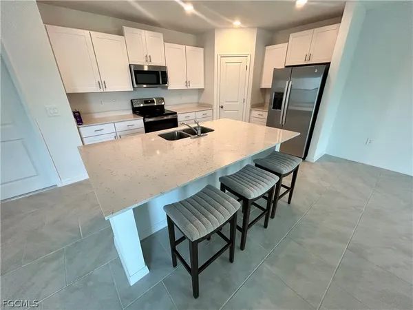 a kitchen with a table chairs refrigerator and a sink