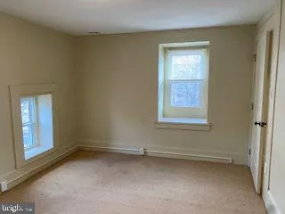 an empty room with windows and closet