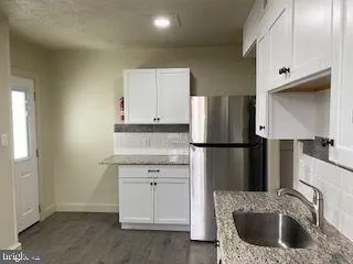 a kitchen with a refrigerator sink and cabinets