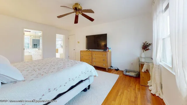 a bedroom with a bed and a flat tv screen on dresser