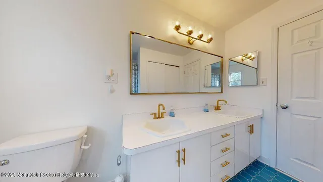 a bathroom with a sink a toilet and mirror