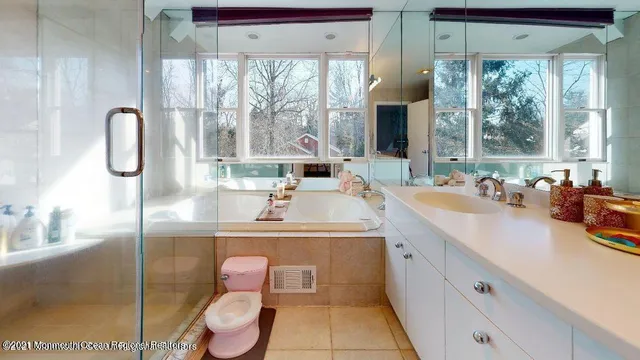 a bathroom with a double vanity sink toilet and a tub