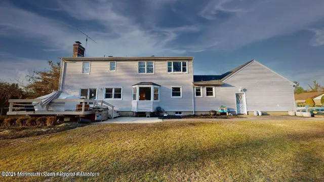 a front view of house with yard and trees in the background