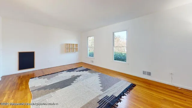 a view of a bedroom with wooden floor and window