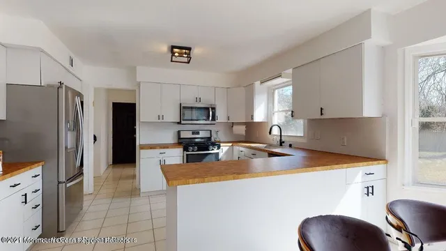 a kitchen with stainless steel appliances granite countertop a sink refrigerator stove and microwave