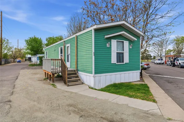 a view of a house with a yard plants and wooden fence