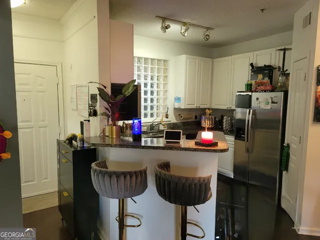a kitchen with stainless steel appliances granite countertop a refrigerator and a table