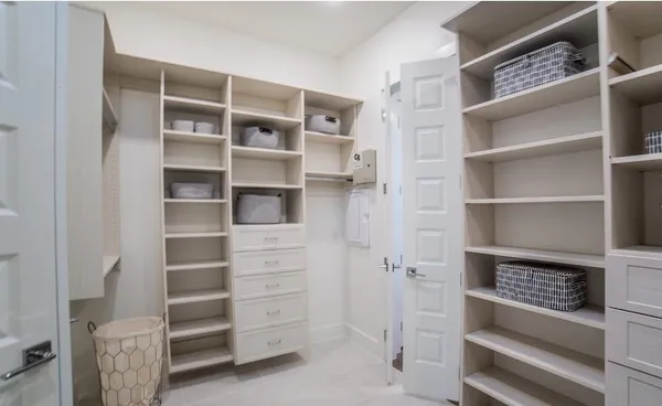 a view of walk in closet with empty racks