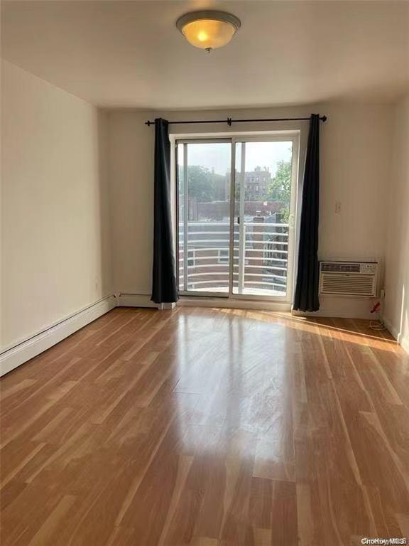 132-73 Maple Avenue, Unit 4A Queens, NY 11355 - Photo 6 of 10 a view of an empty room with wooden floor and a window