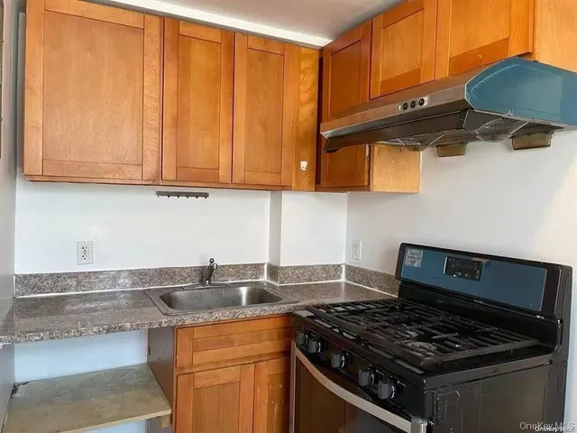a kitchen with stainless steel appliances granite countertop a sink stove and cabinets