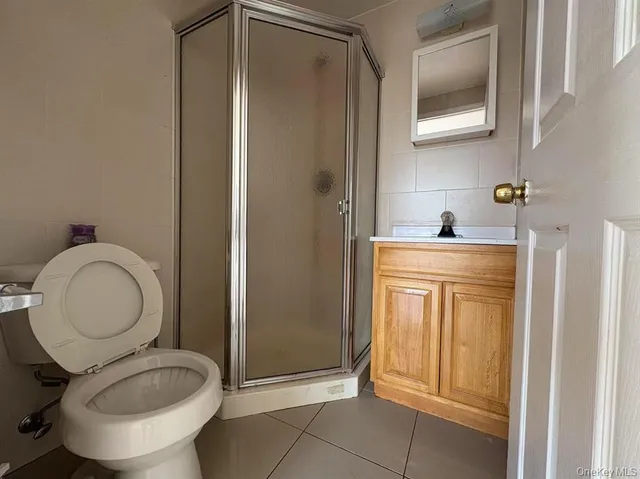 a bathroom with a granite countertop toilet sink and mirror