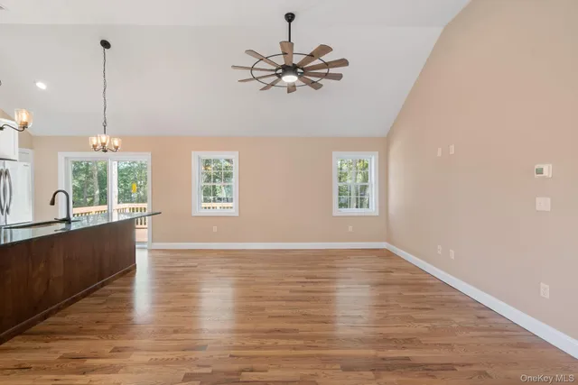 a kitchen with stainless steel appliances kitchen island wooden floors and white cabinets