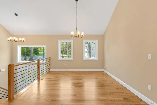 a view of a room with wooden floor staircase and a kitchen