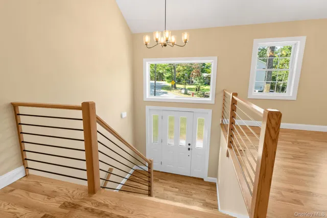 a view of an empty room with wooden floor and window