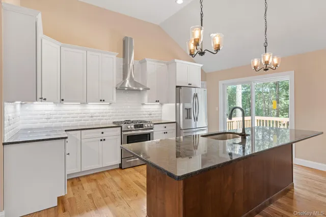 a kitchen with granite countertop a sink a counter top space appliances and cabinets