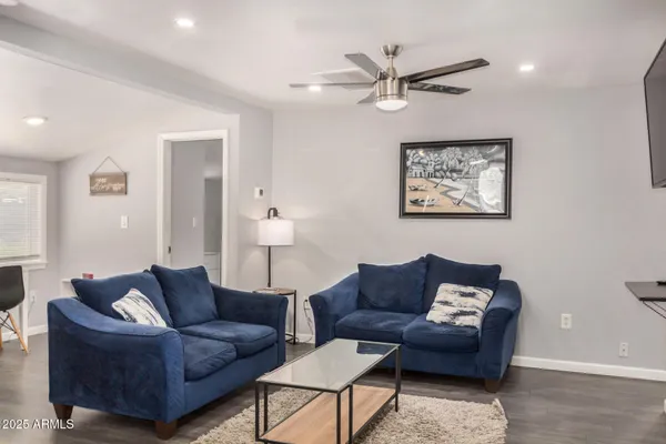 a living room with furniture a ceiling fan and a window