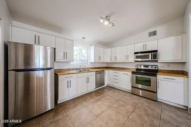 a kitchen with granite countertop white cabinets and stainless steel appliances