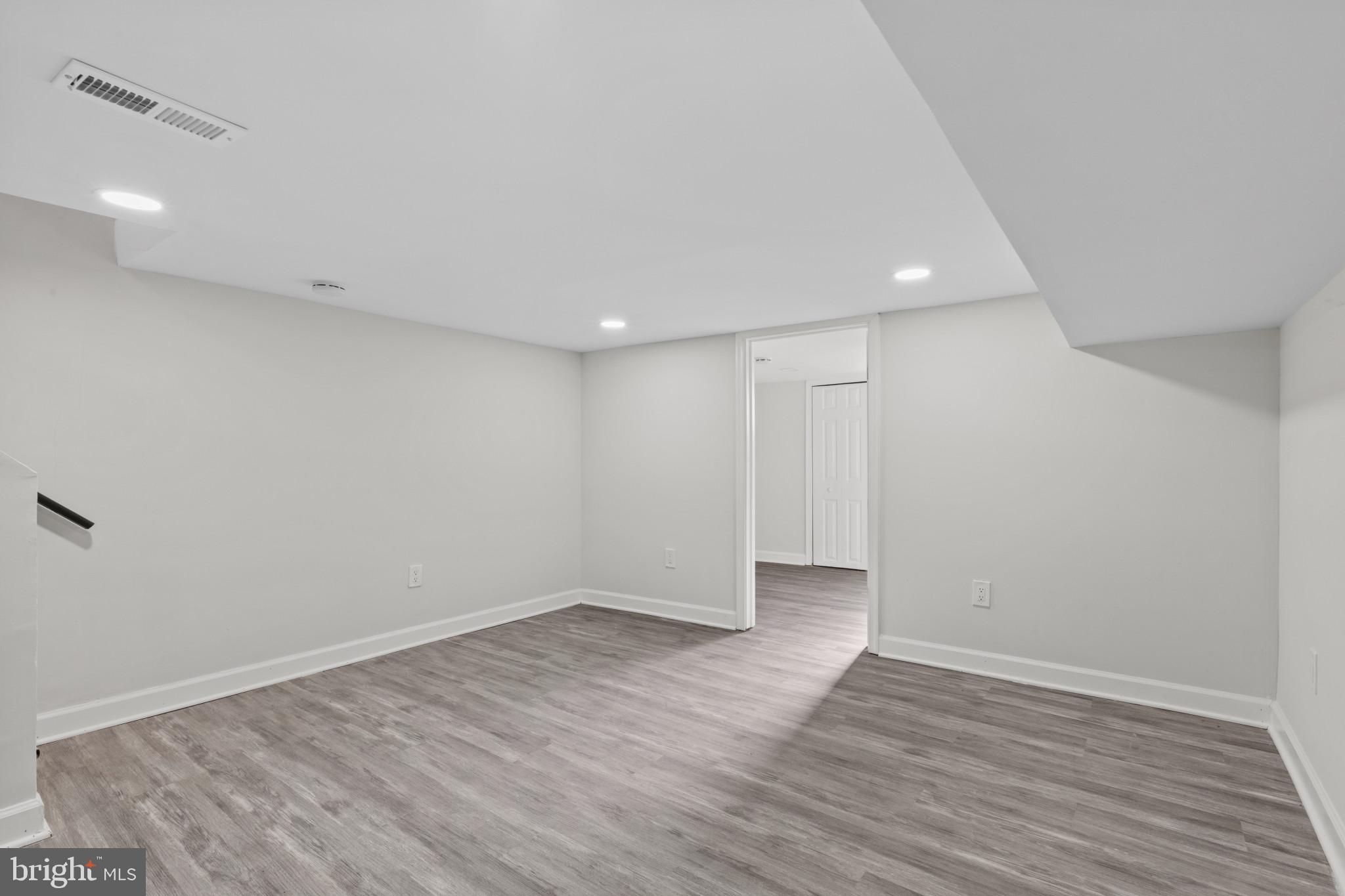 3404 East Pratt Street Baltimore, MD 21224 - Photo 22 of 39 a view of an empty room with wooden floor and a window