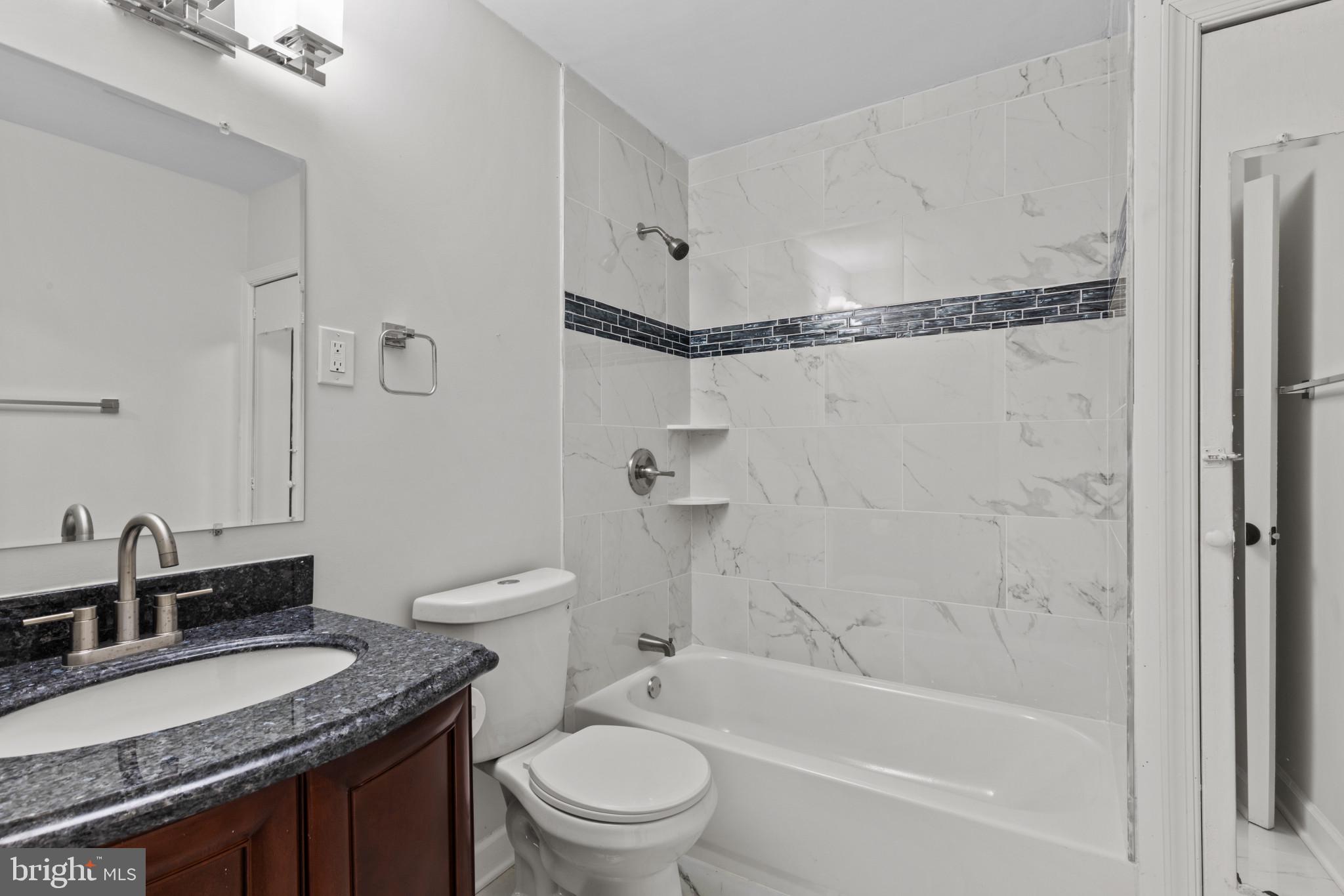 3404 East Pratt Street Baltimore, MD 21224 - Photo 29 of 39 a bathroom with a granite countertop sink toilet and shower