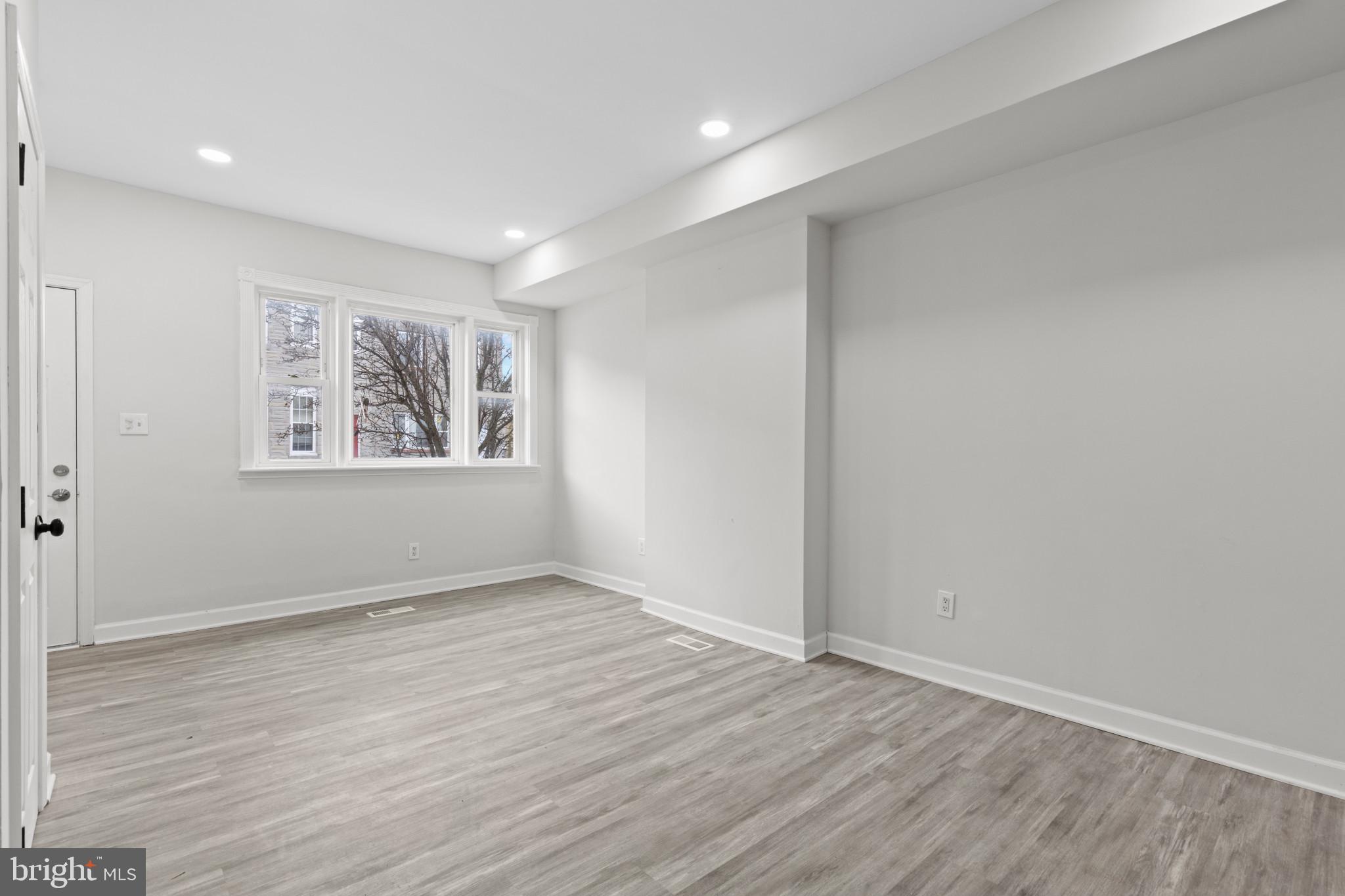 3404 East Pratt Street Baltimore, MD 21224 - Photo 4 of 39 a view of an empty room with wooden floor and a window
