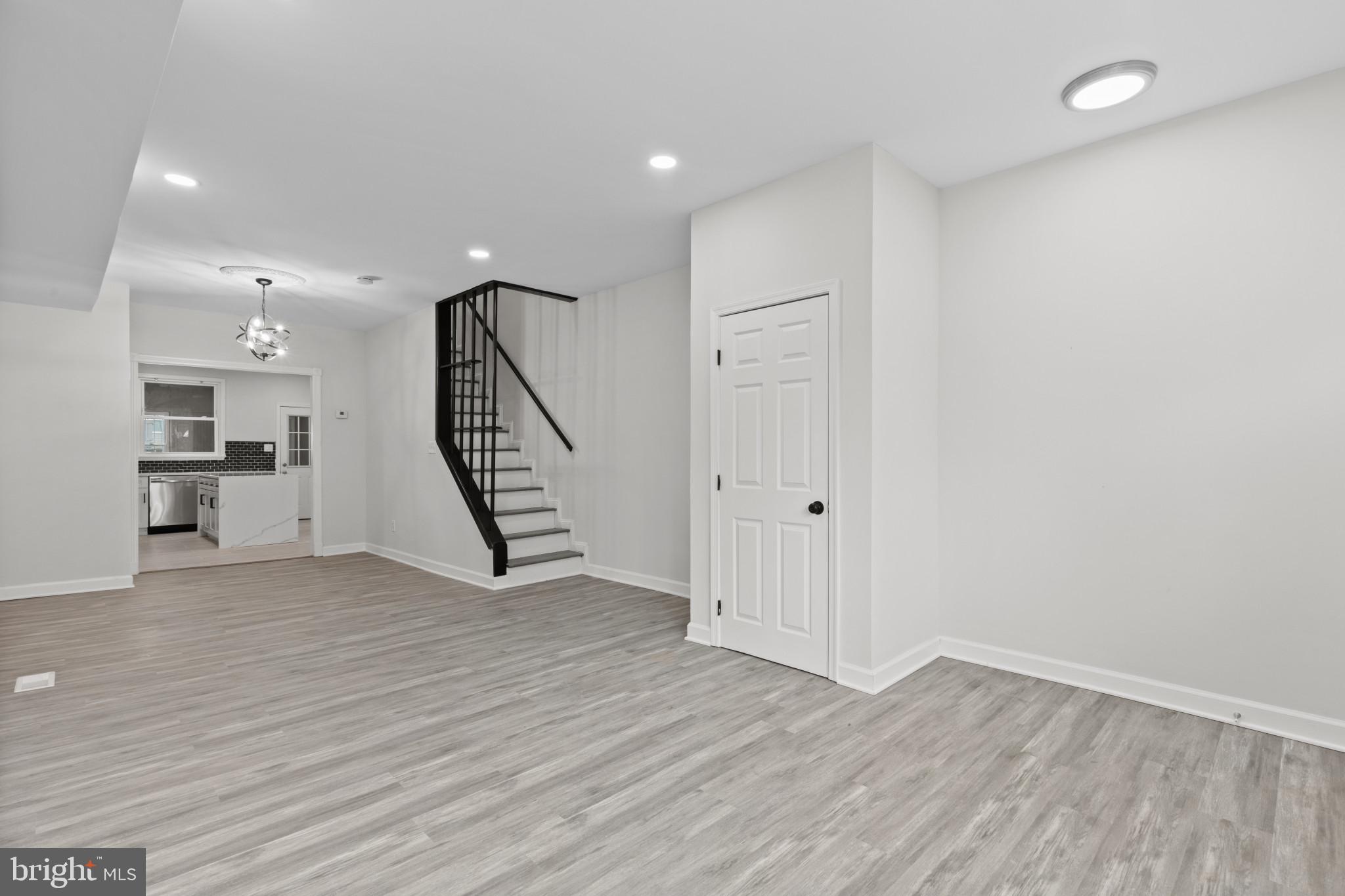 3404 East Pratt Street Baltimore, MD 21224 - Photo 6 of 39 a view of an empty room with wooden floor and stairs