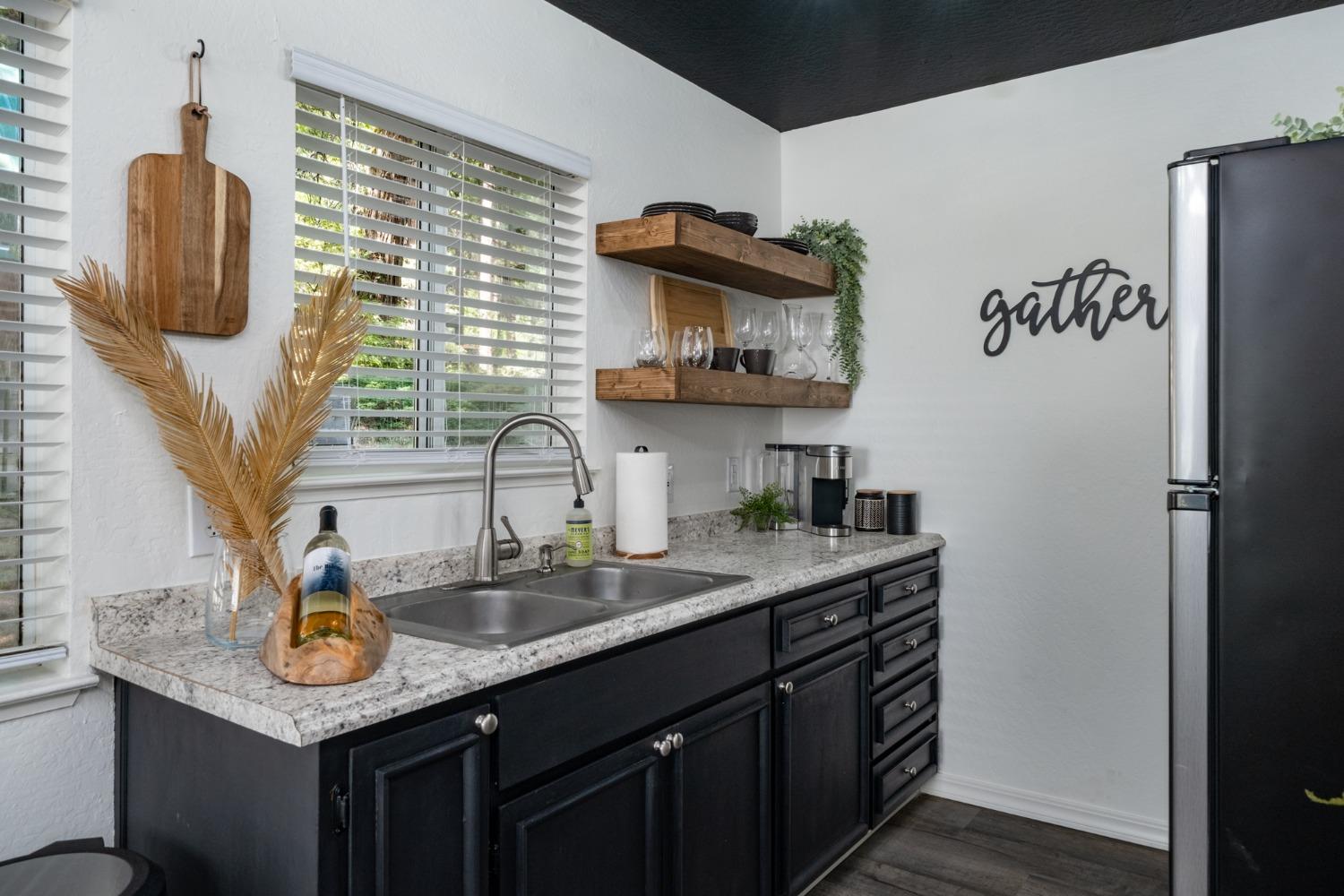 25941 Ellmaro Road Long Barn, CA 95335 - Photo 16 of 74 a kitchen with stainless steel appliances granite countertop a sink and a refrigerator
