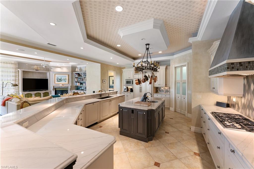 590 17th Avenue South Naples, FL 34102 - Photo 11 of 50 a large white kitchen with a large counter top furniture and appliances