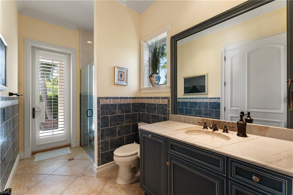 590 17th Avenue South Naples, FL 34102 - Photo 14 of 50 a bathroom with a sink a toilet and mirror